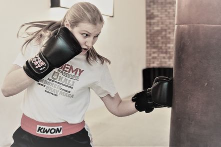 Junge Frau boxt gegen einen Boxsack